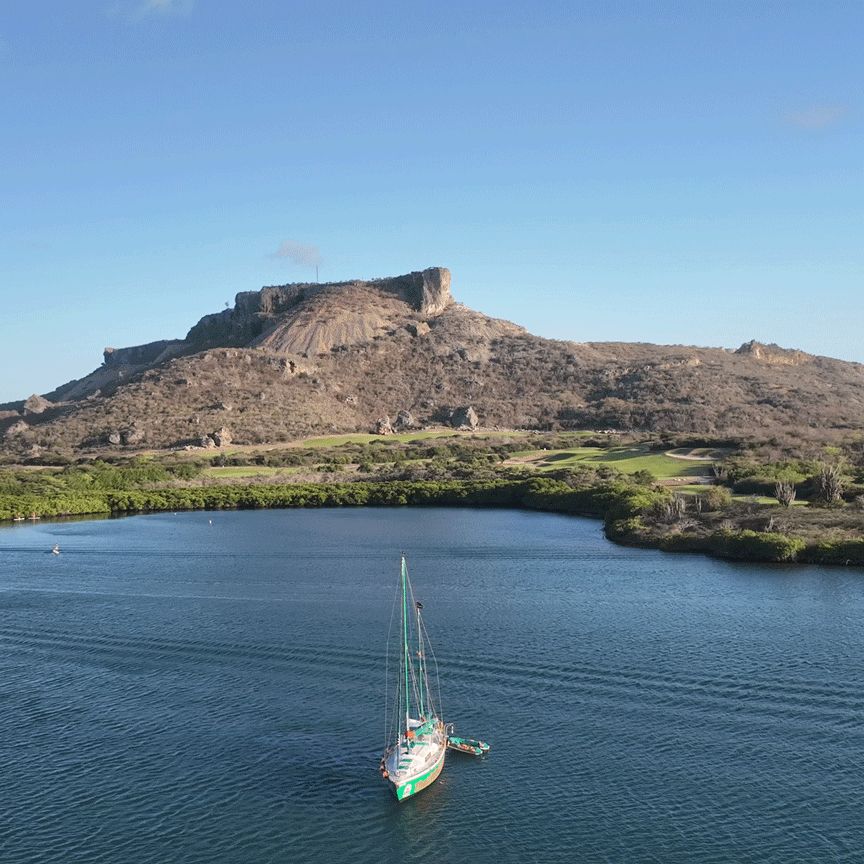 Voilier mouillé devant la falaise plate du Tafelberg, à Curaçao.