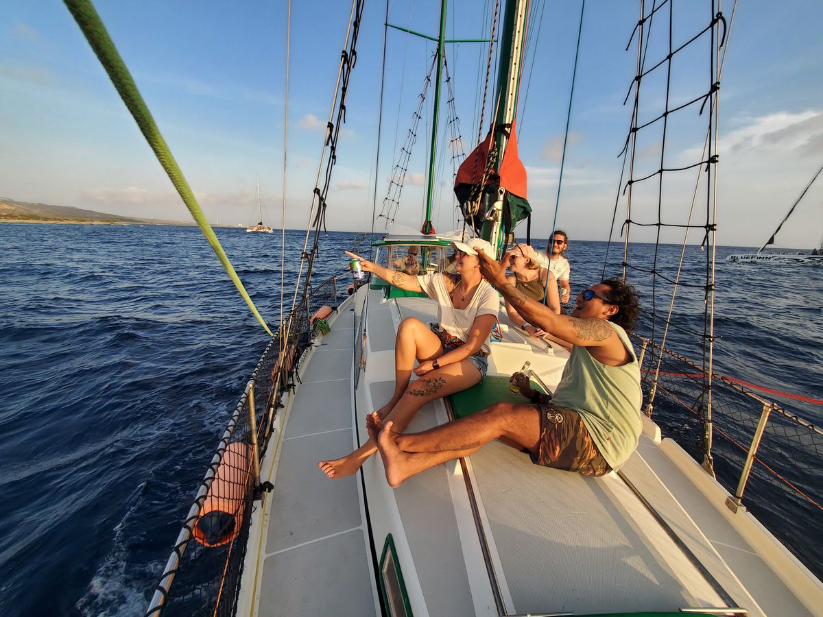 Passagers détendus sur le pont du voilier pendant la croisière privée à Curaçao.
