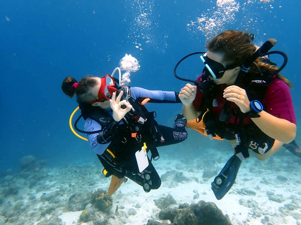 Monitrice accompagnant une plongeuse débutante sous l'eau, à Curaçao.