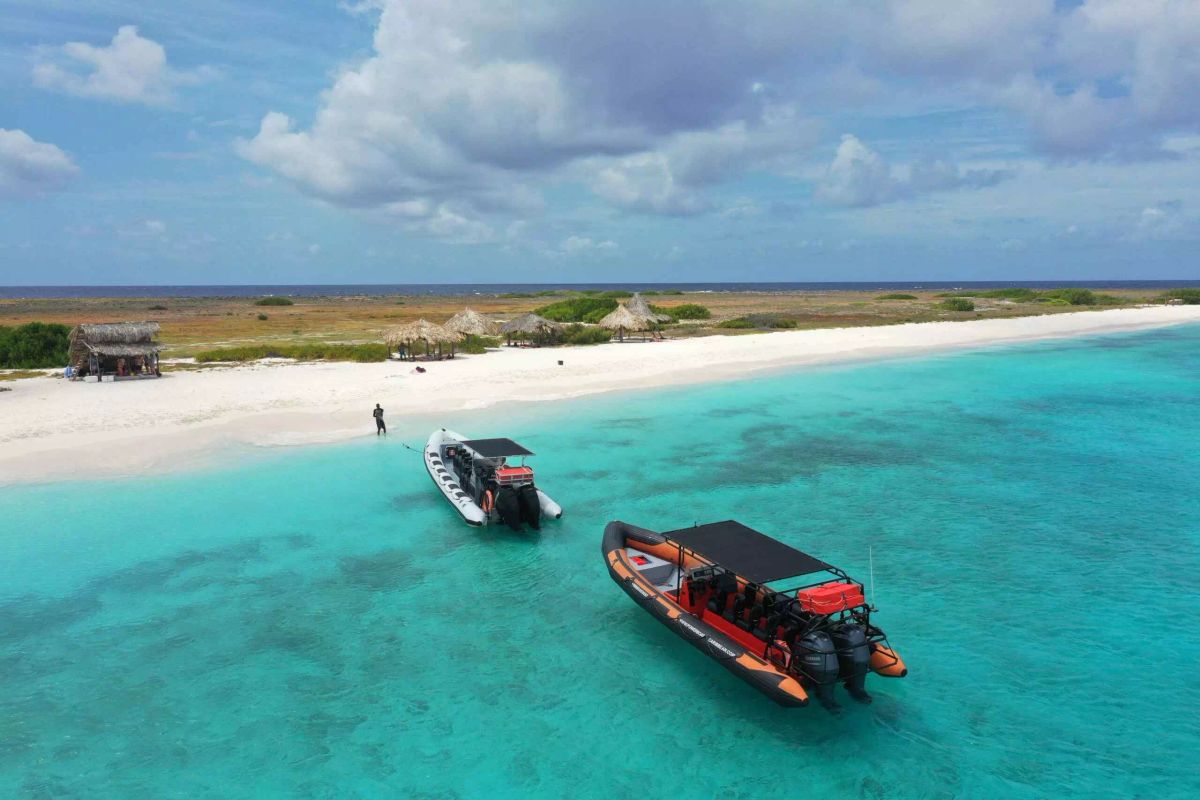 Bateaux rapides accostés sur la plage de sable blanc de Klein Curaçao.