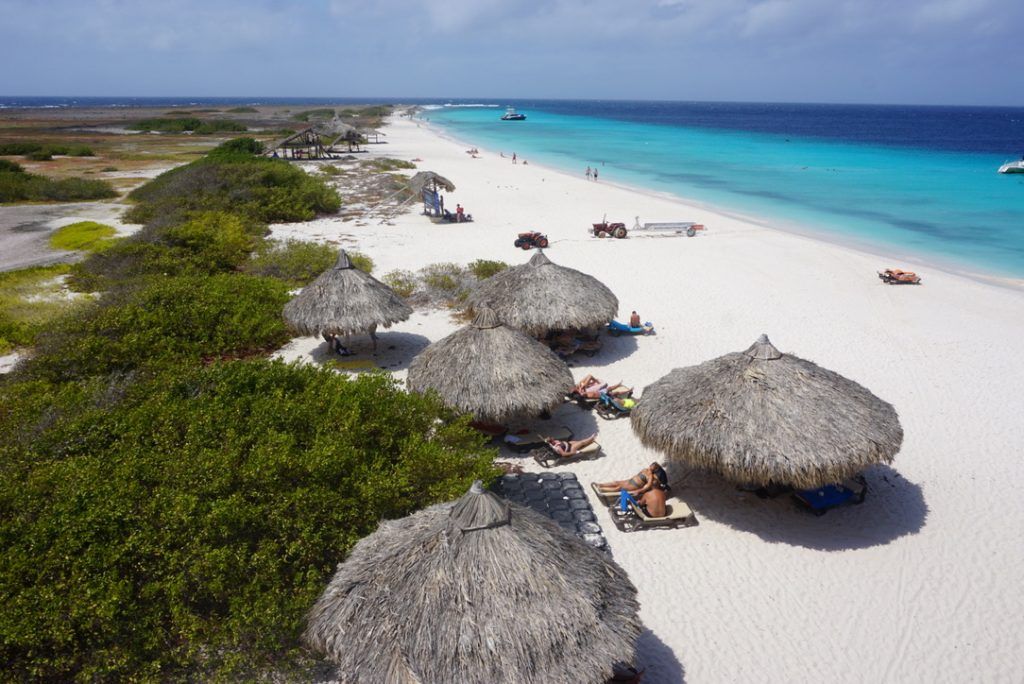 Paillotes alignées sur la longue plage de sable blanc de Klein Curaçao.
